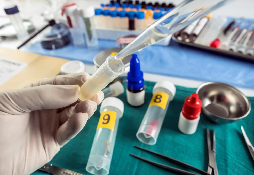 Technician pipetting liquid into numbered sample tubes