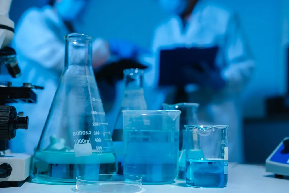 Beakers and flasks of blue liquid on a laboratory bench