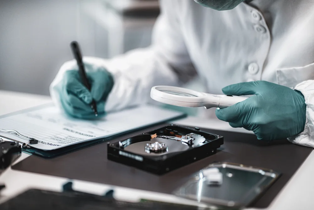 Technician documenting an opened hard drive