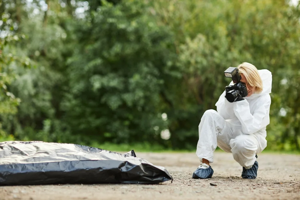 Investigator photographing evidence at an outdoor scene