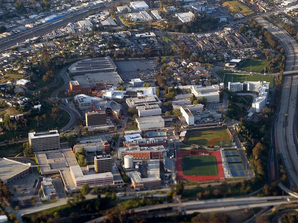 An aerial view of the California State University, Los Angeles campus with its athletics field and hillside setting