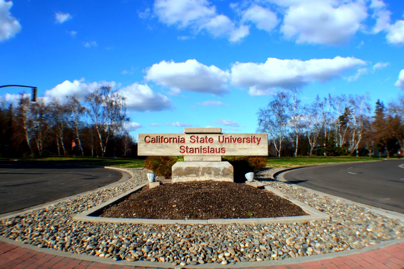The California State University, Stanislaus campus entrance sign set in landscaped stonework