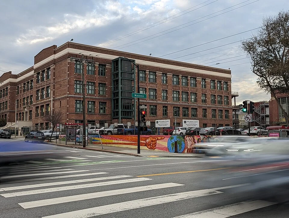 A multi-storey brick City College of San Francisco building on a downtown street corner