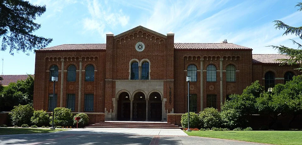 The historic brick main building at Fresno City College behind a lawn and pathway