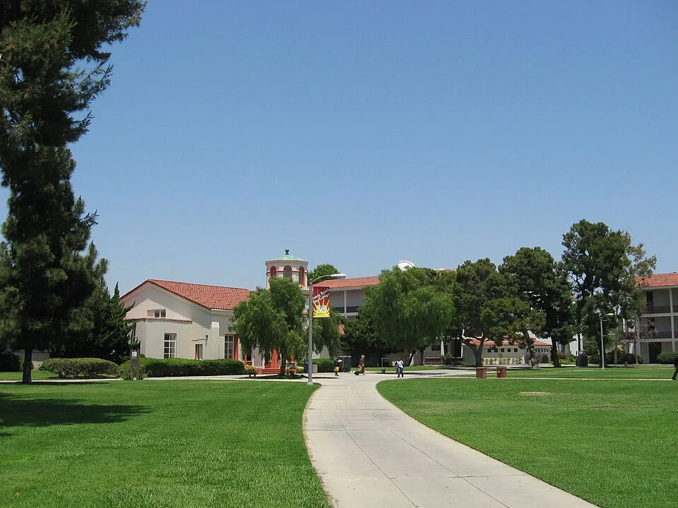 A wide lawn and walkway leading to red-roofed campus buildings at Long Beach City College