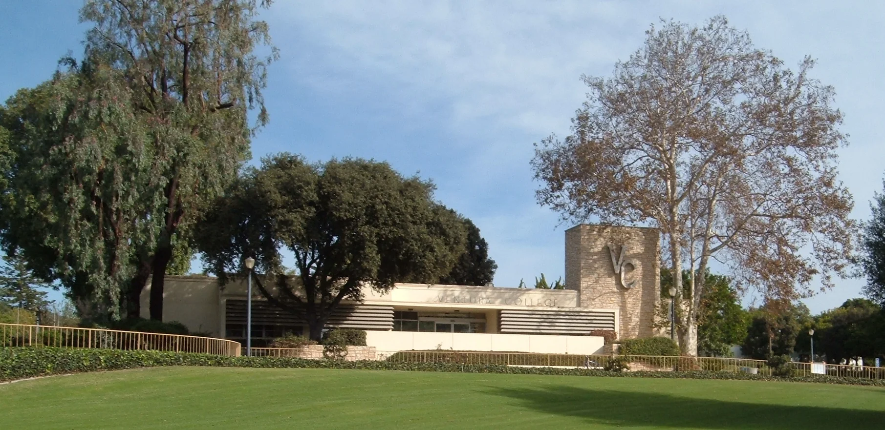 The administration building at Ventura College beyond a broad lawn and mature trees