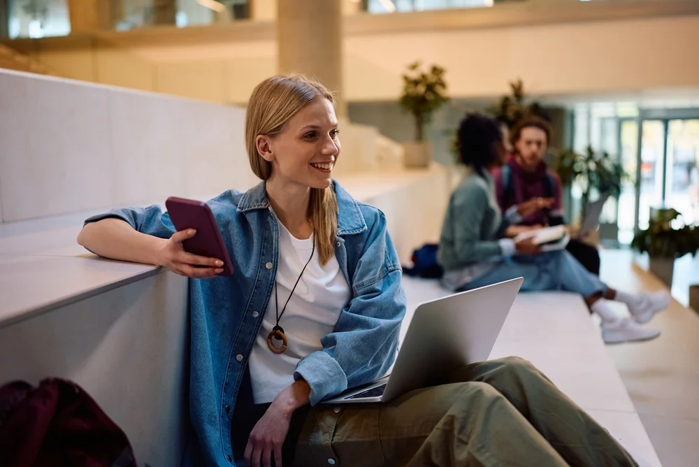 Student with a laptop in a campus lounge