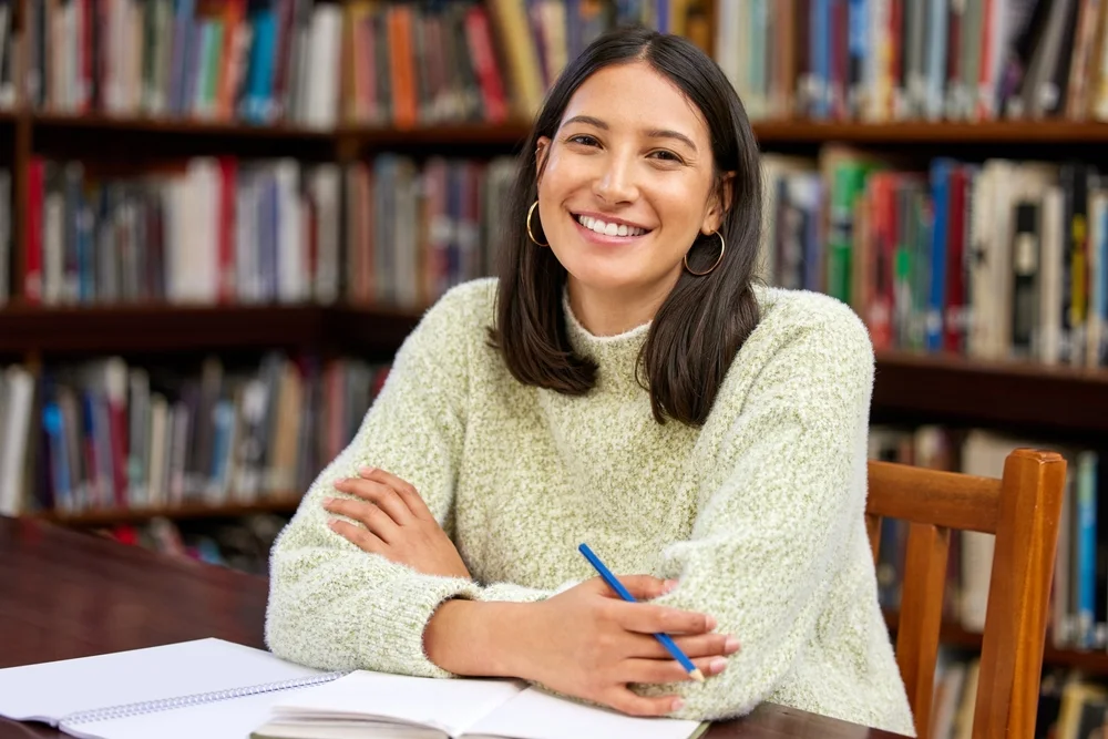 Student studying at a table in a library